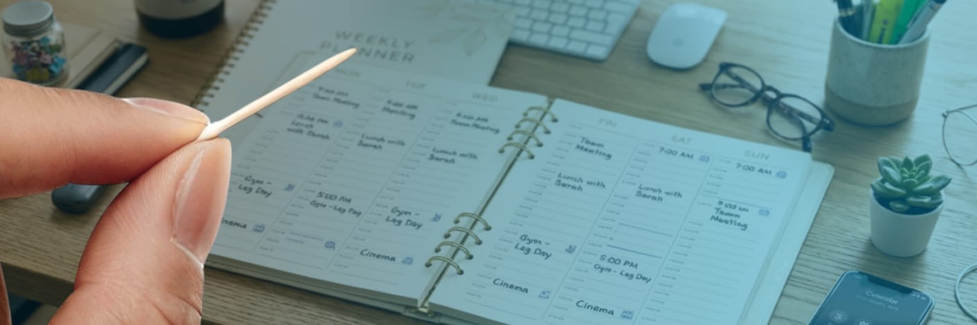person holding a nicleaf next to a day planner